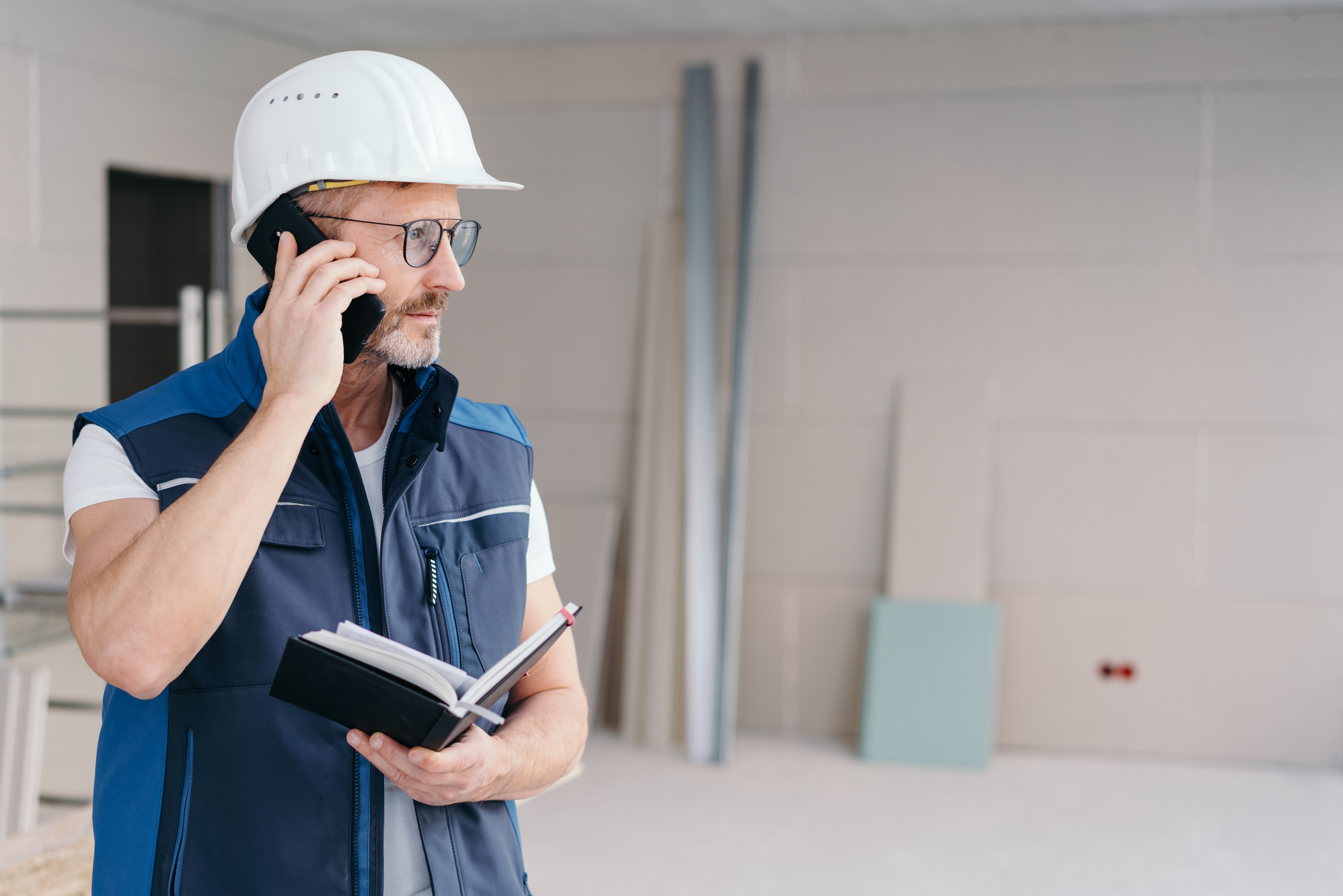 Contractor on the phone reviewing leads at a job site