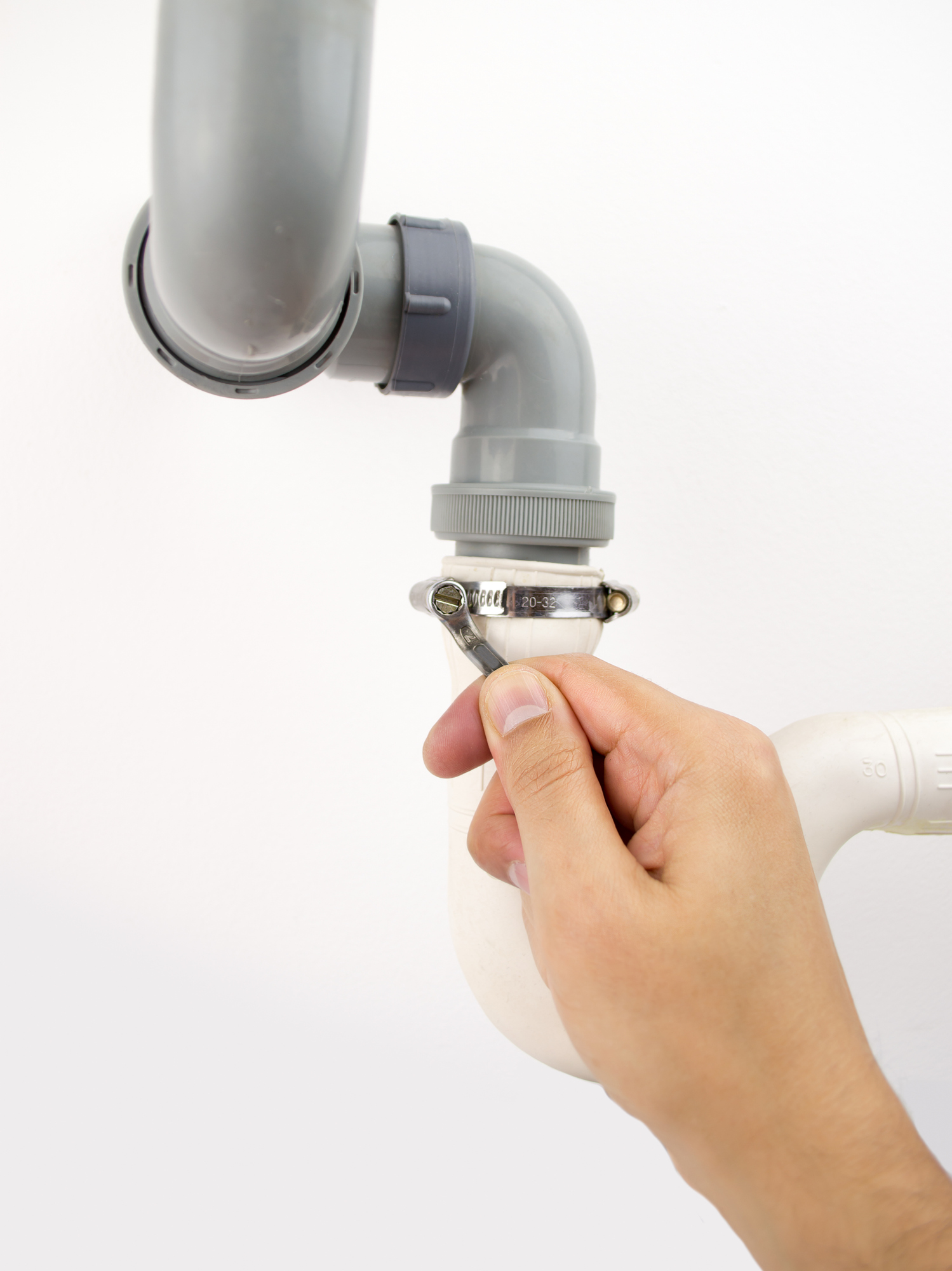 Plumber with hands full on a pipe while calls go unanswered