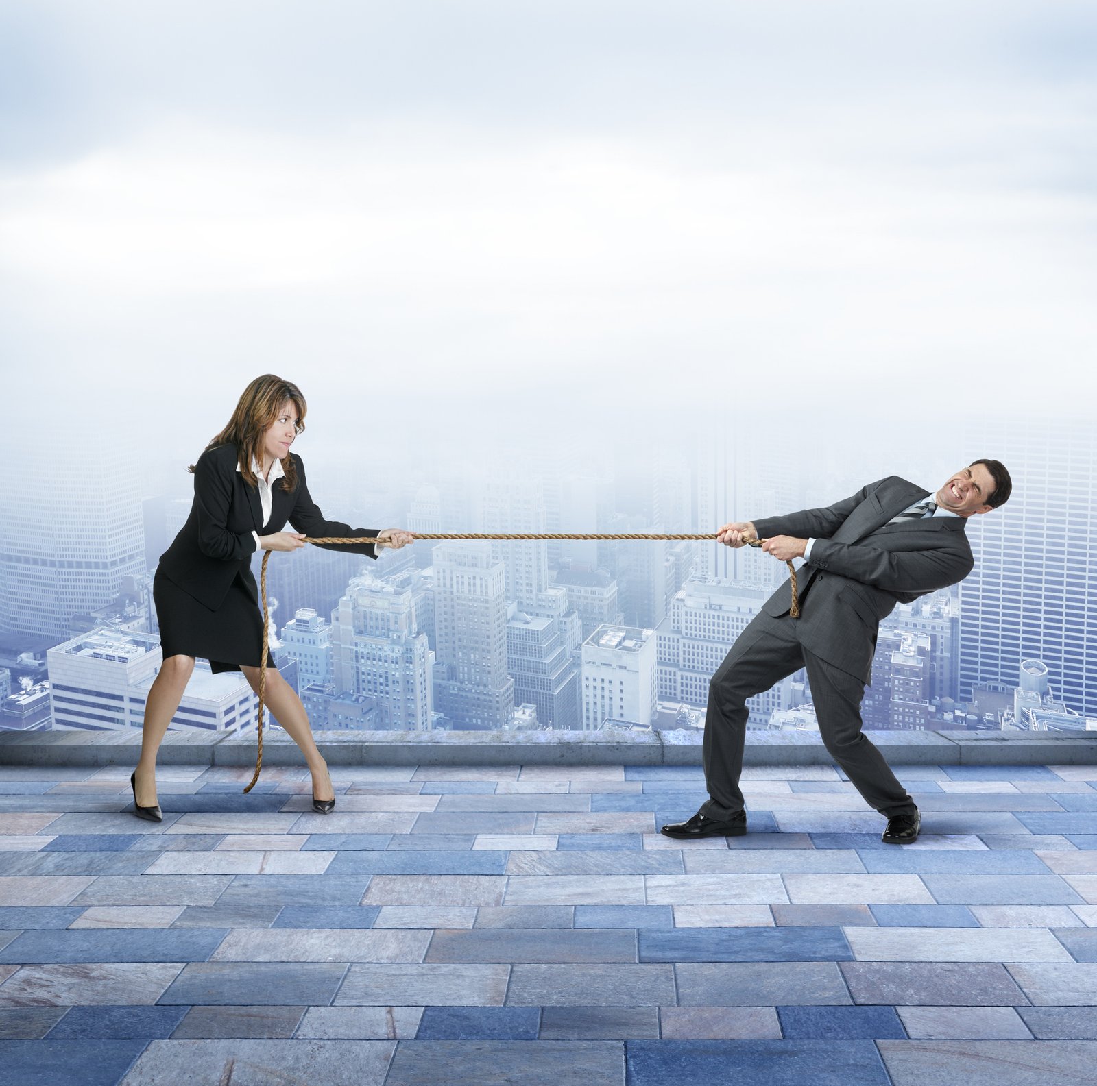 Two businesspeople in a tug of war over the same lead