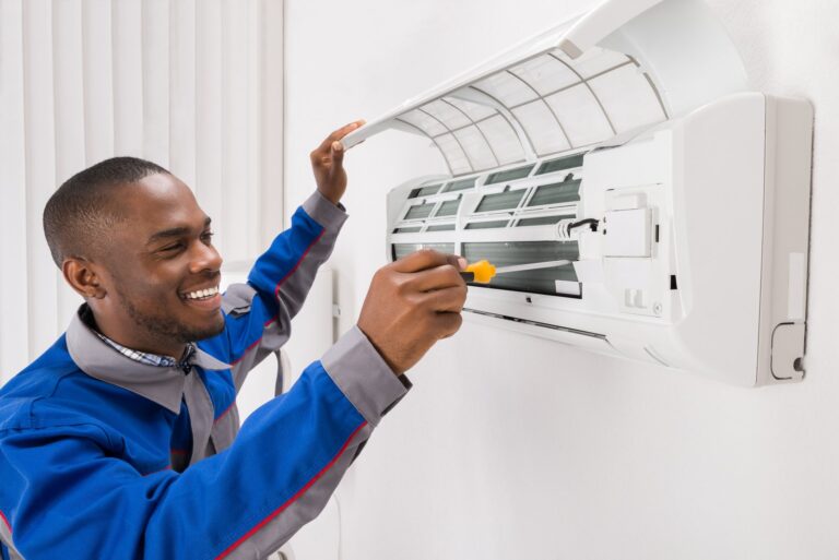 HVAC technician servicing a wall-mounted air conditioning unit